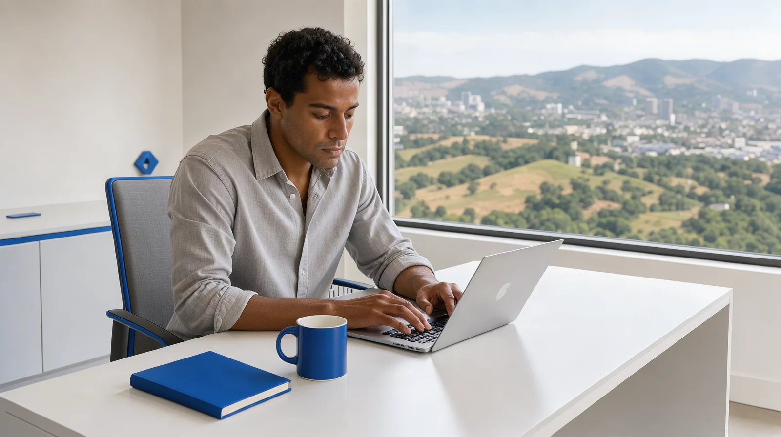 Marketing digital em Jundiaí: guia para prestadores de serviço Profissional trabalhando no notebook em escritório claro, com janela para uma cidade do interior cercada de morros
